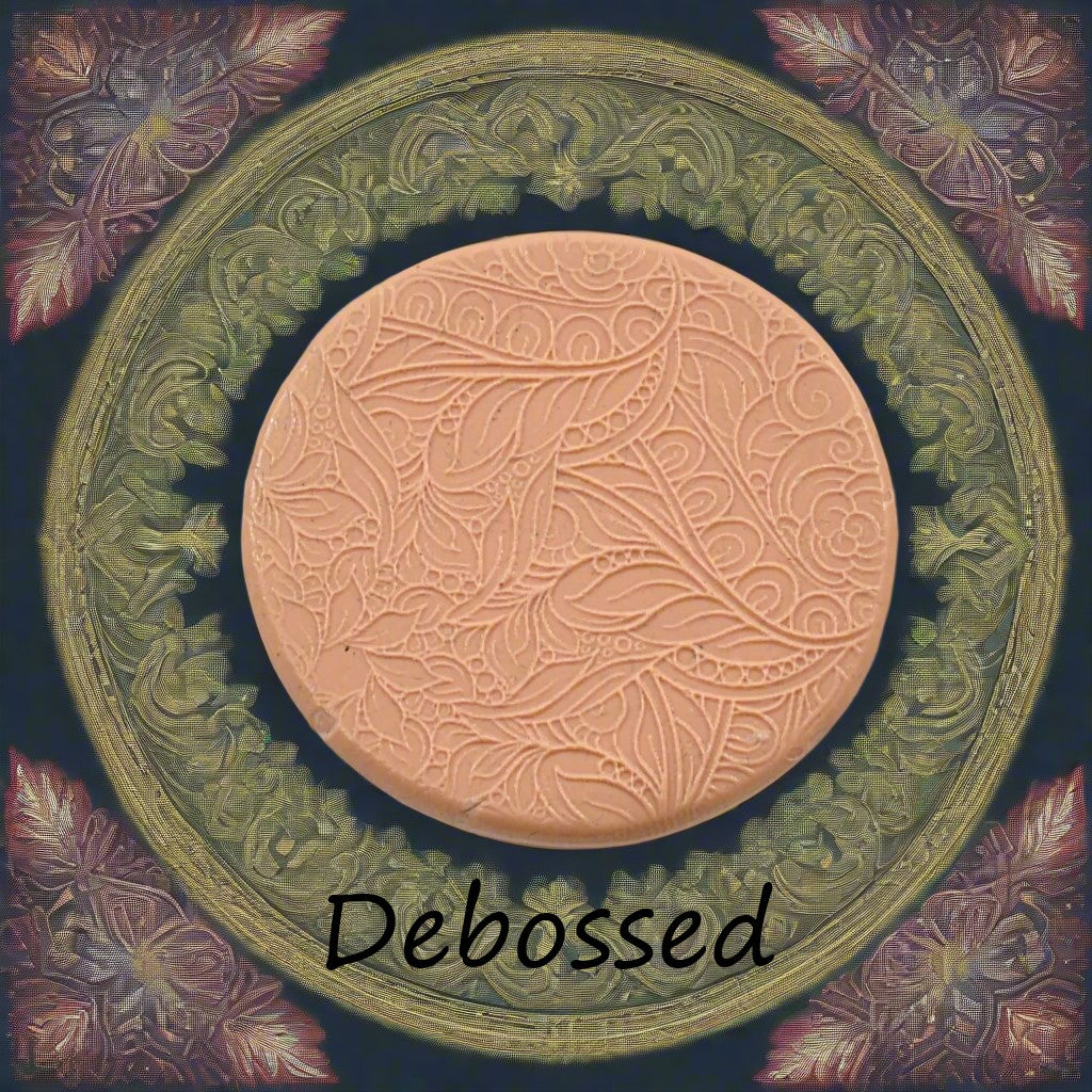 A flowery design embossed in silly putty using a  debossed texture mat. This will give you an idea of what it will look like on metal clay or polymer clay.