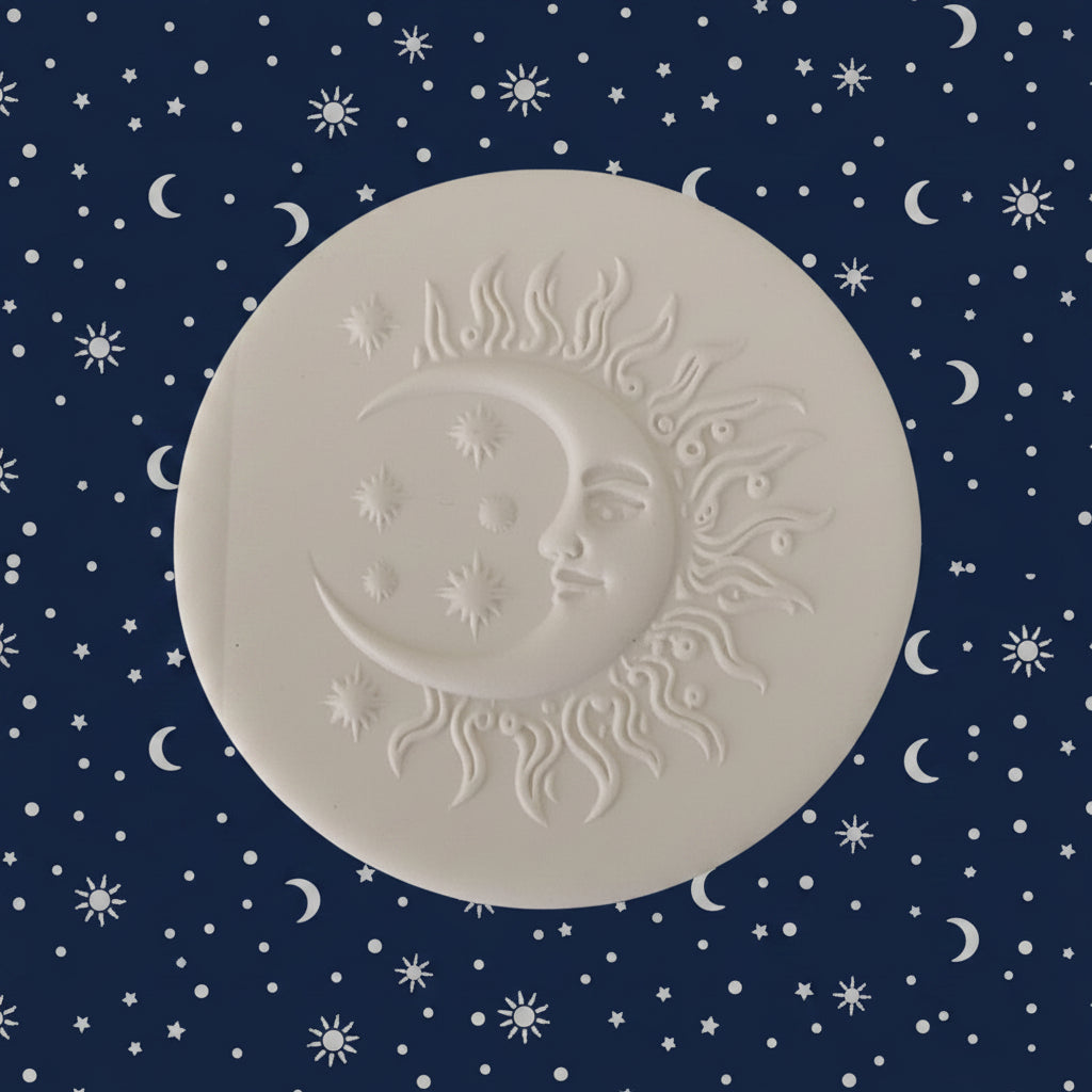 A round clay stamp featuring an embossed crescent moon and sun face design.