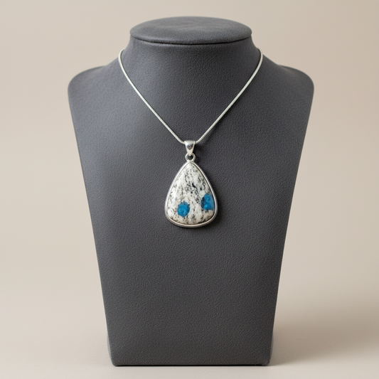 Necklace with a teardrop-shaped pendant on a gray mannequin bust.