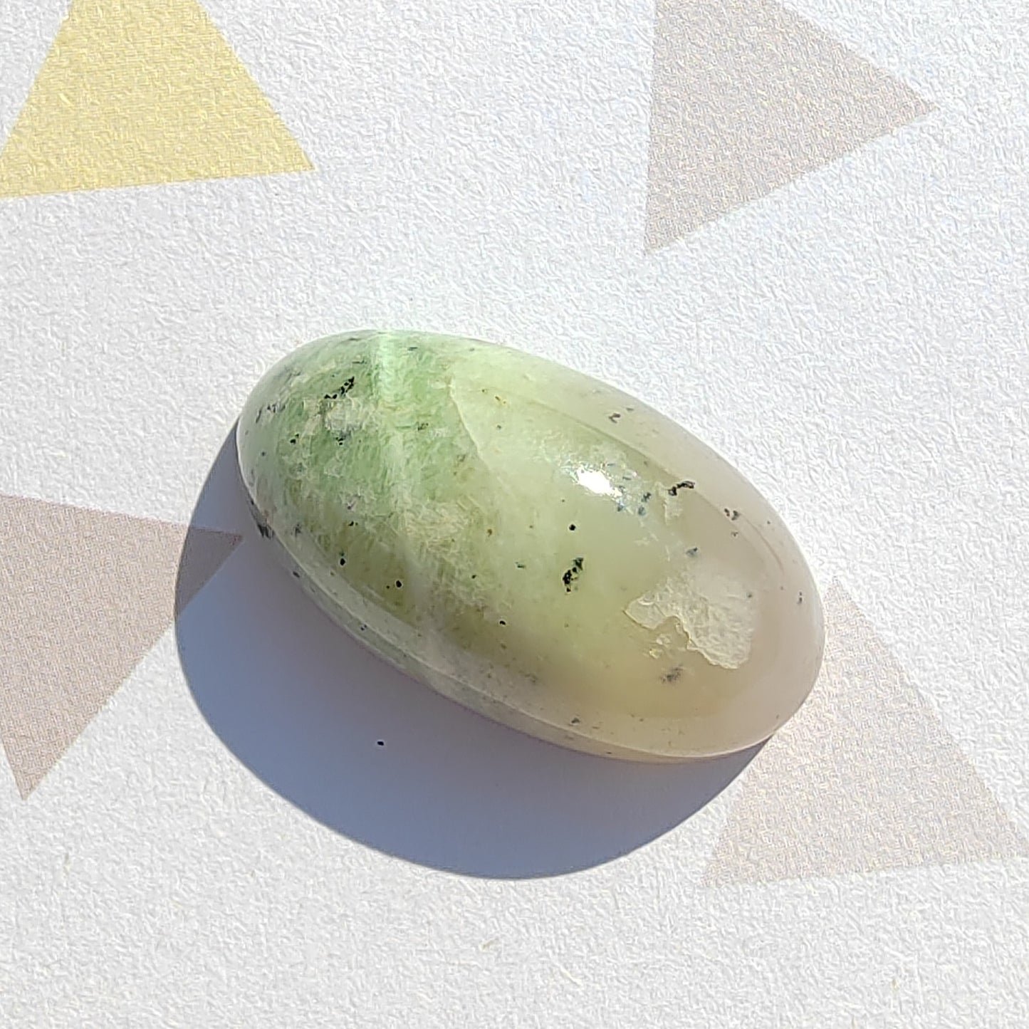 Green stone on a white surface with geometric shapes