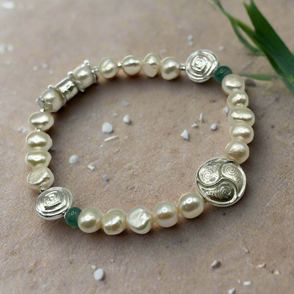 Pearl bracelet with silver beads on a beige surface