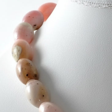 Close-up of a bracelet with pink and beige beads on a white background