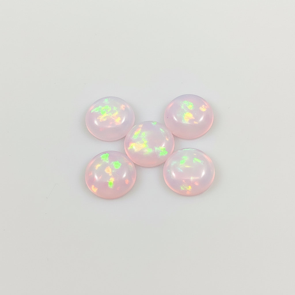 Five pink opal stones on a light background