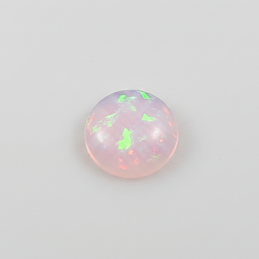  round opal stones with a pinkish hue on a light grey background