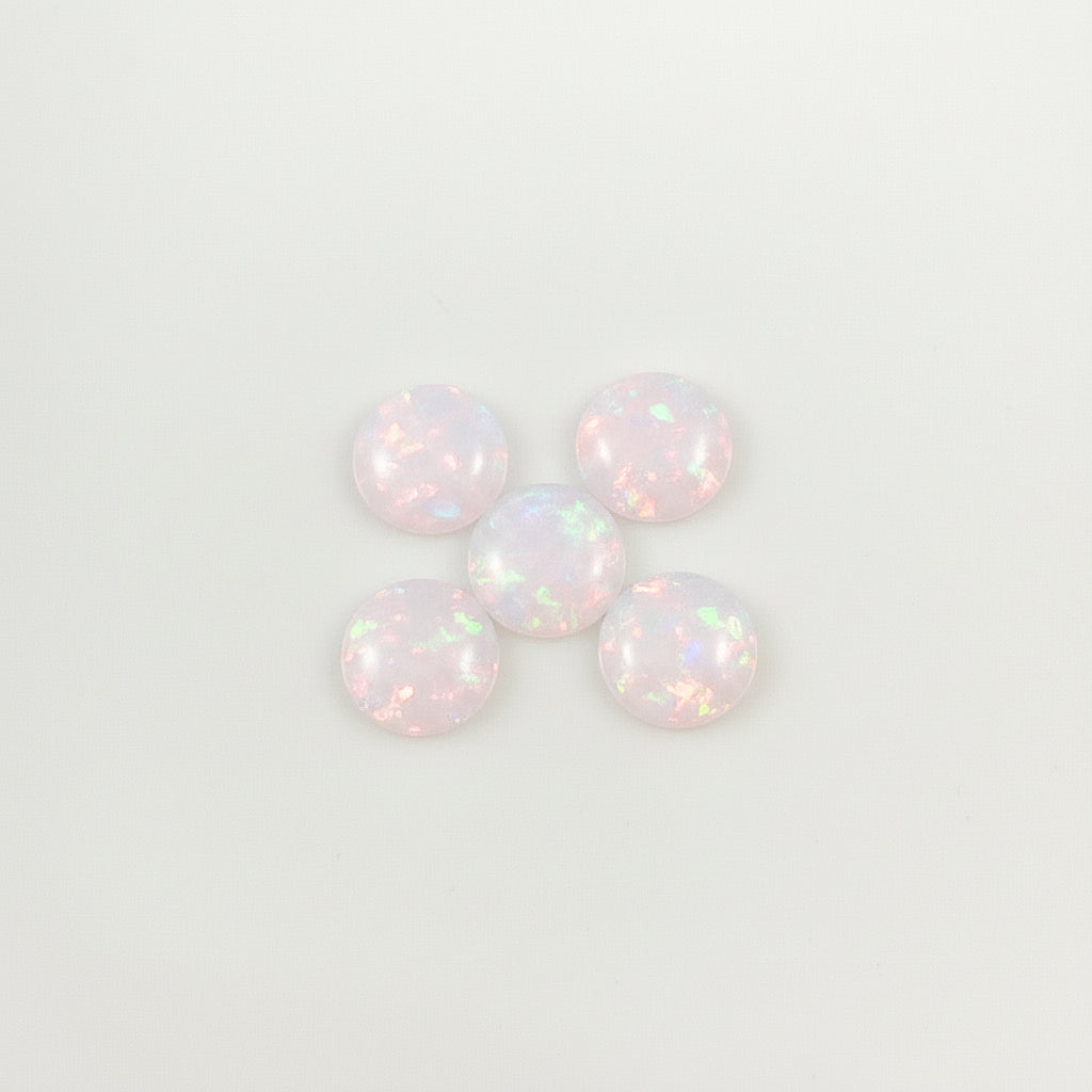 Five iridescent opals on a light  background