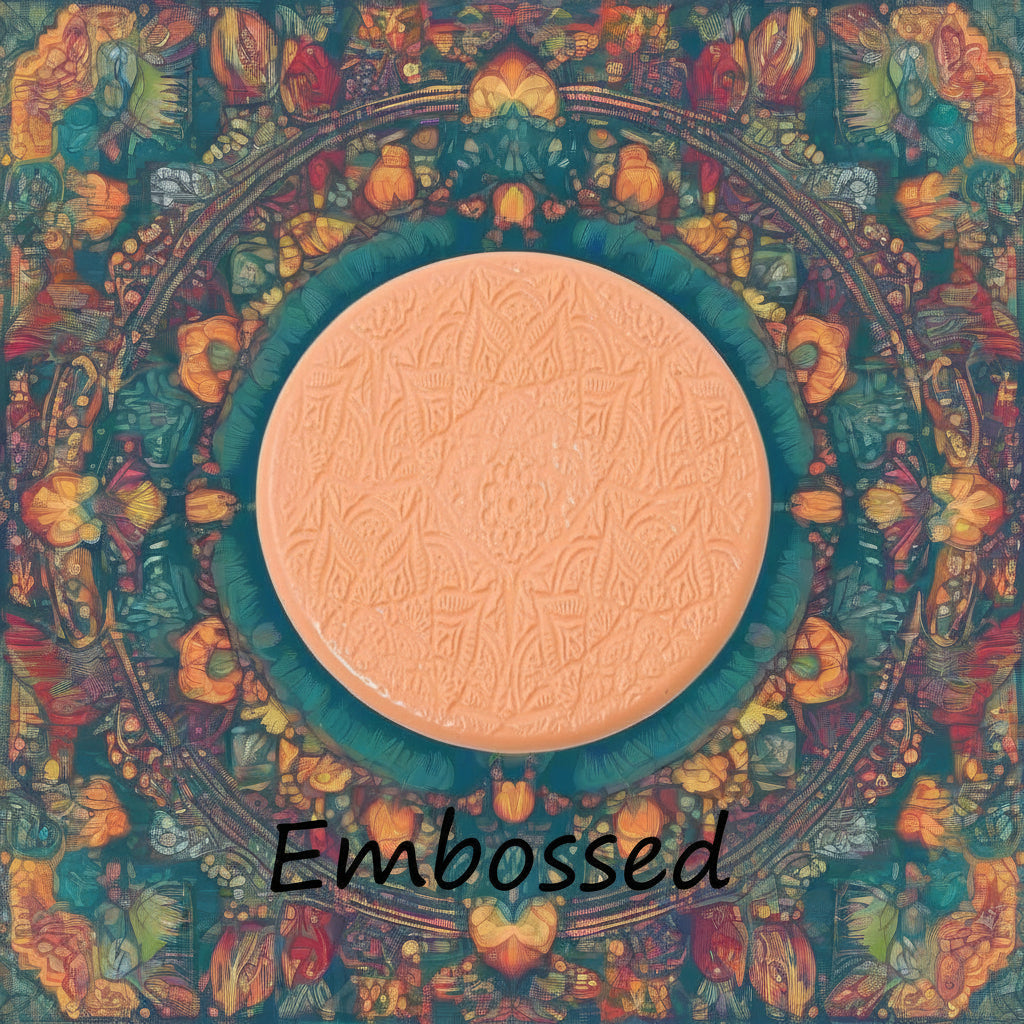 A lacey flowery mandala pattern debossed in silly putty Using a embossed texture mat in grey material. This will give you an idea of what it will look like on metal clay or polymer clay.