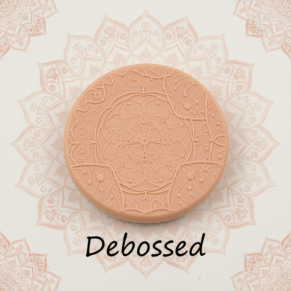 A flowery mandala pattern embossed in silly putty Using a debossed texture mat in grey material. This will give you an idea of what it will look like on metal clay or polymer clay.