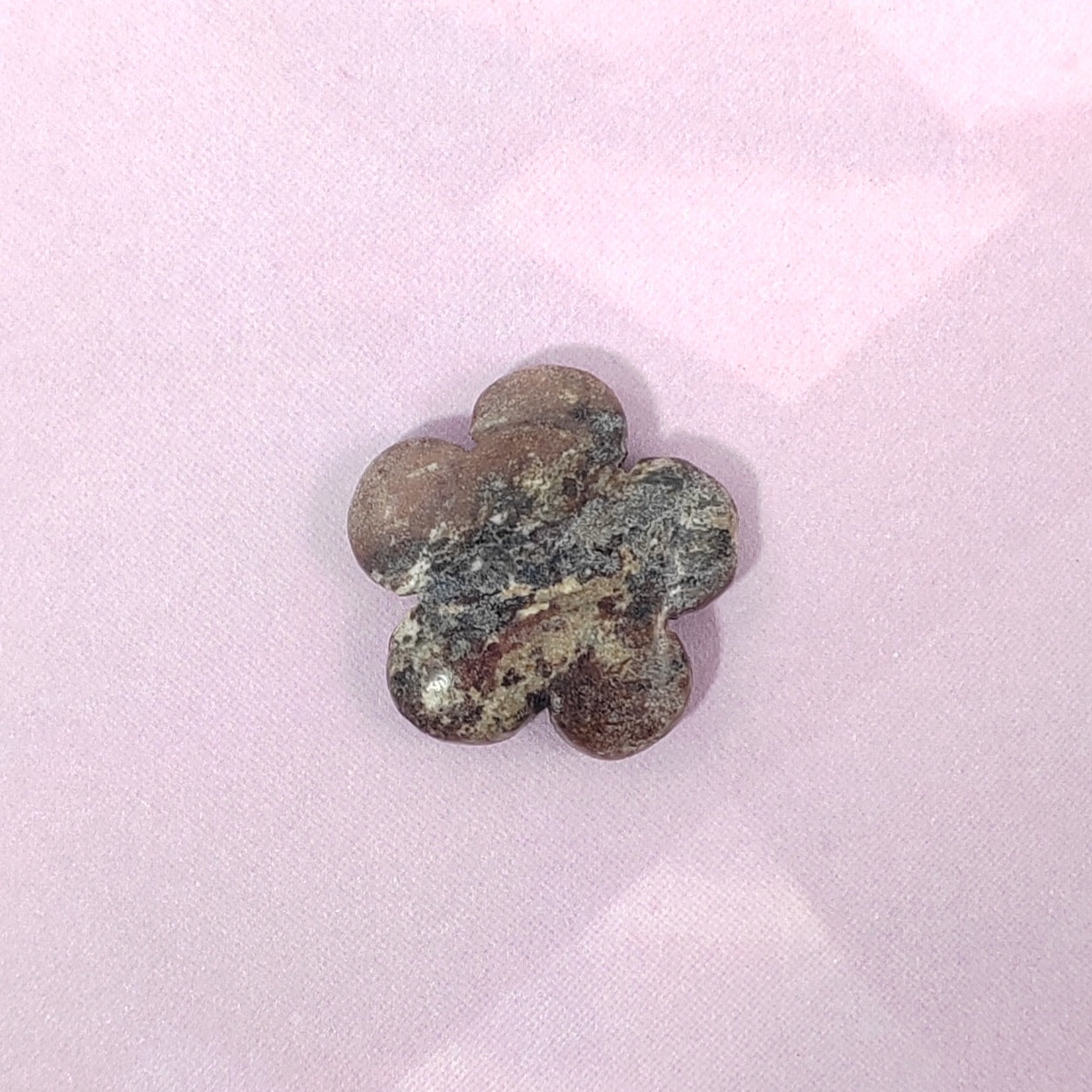 Flower-shaped metal object on a pink background