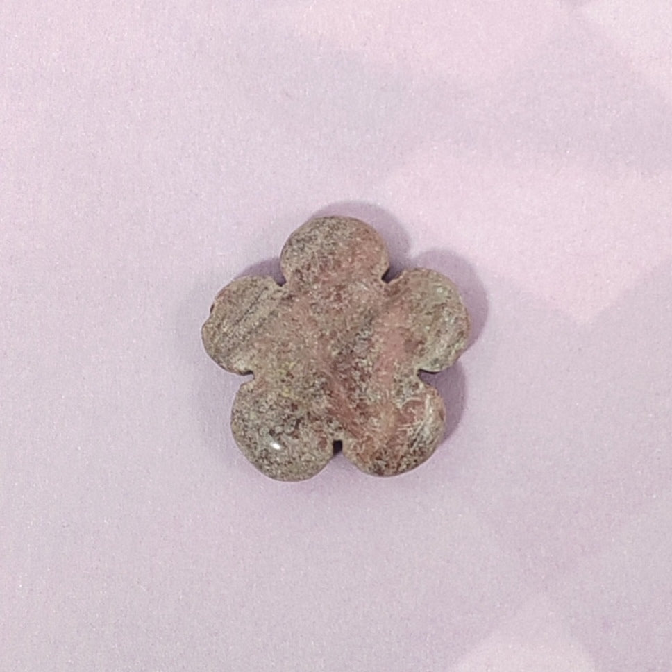Flower-shaped stone on a light pink background