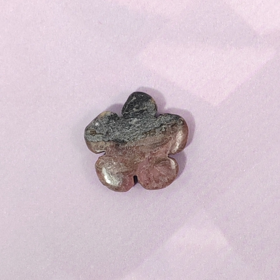 Flower-shaped stone on a light pink background