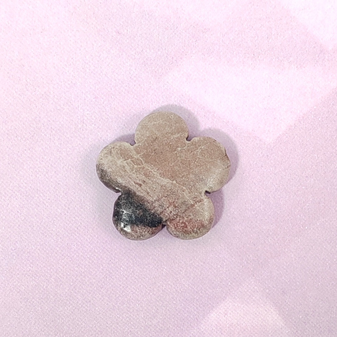 Flower-shaped stone on a pink background