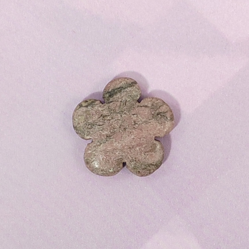 Flower-shaped stone on a light pink background