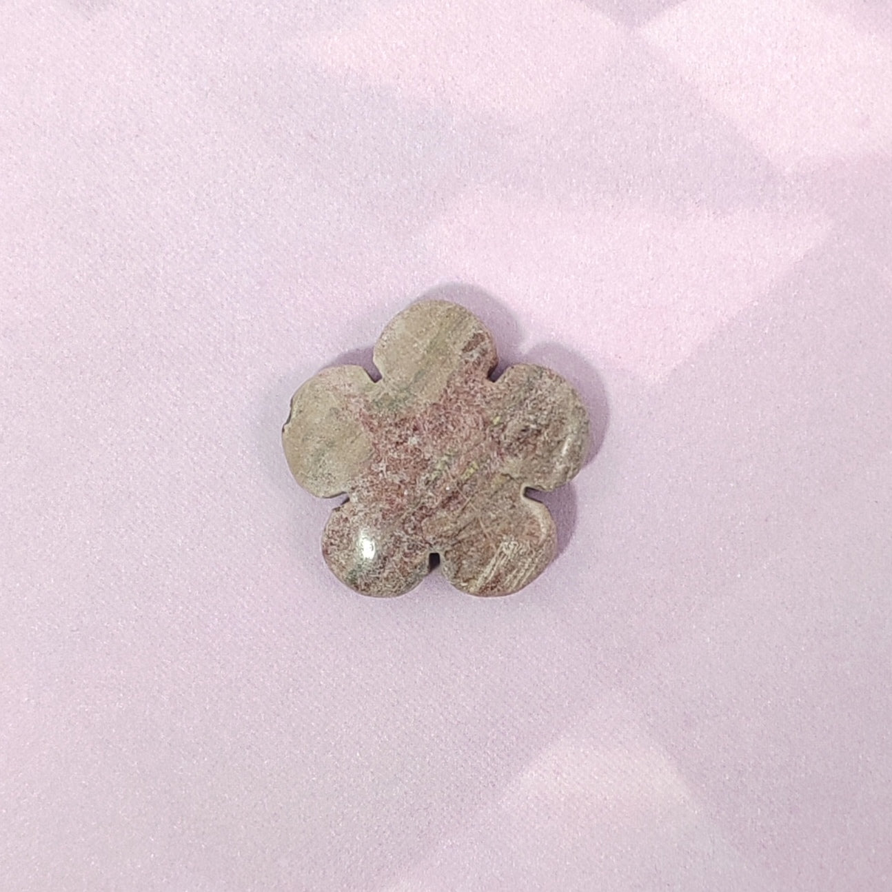 Flower-shaped stone on a pink background