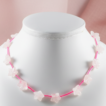 Necklace with pink and white floral beads on a mannequin against a pink background