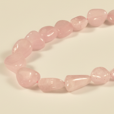Pink beaded bracelet on a light pink background