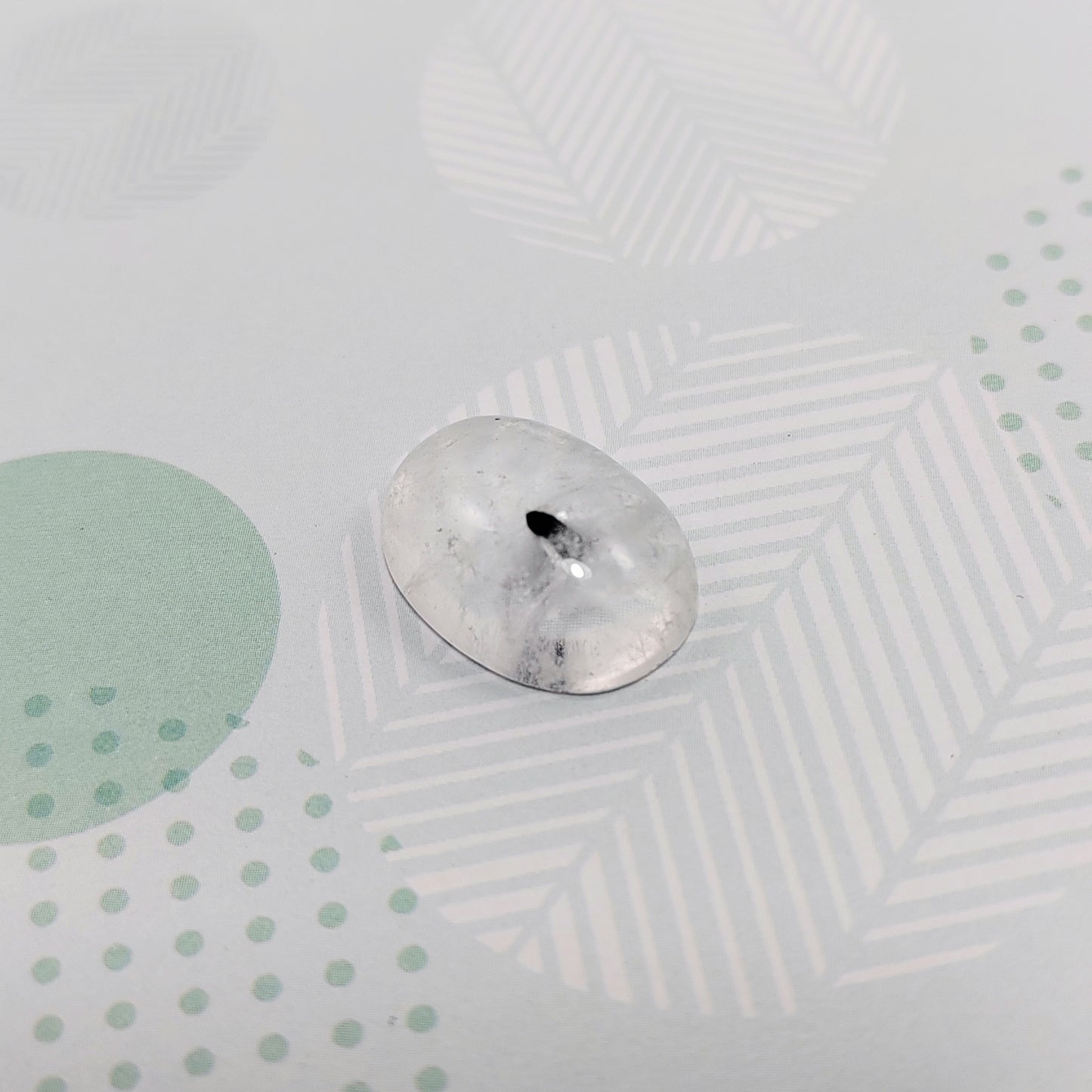 Rutilated quartz on a textured surface with geometric patterns