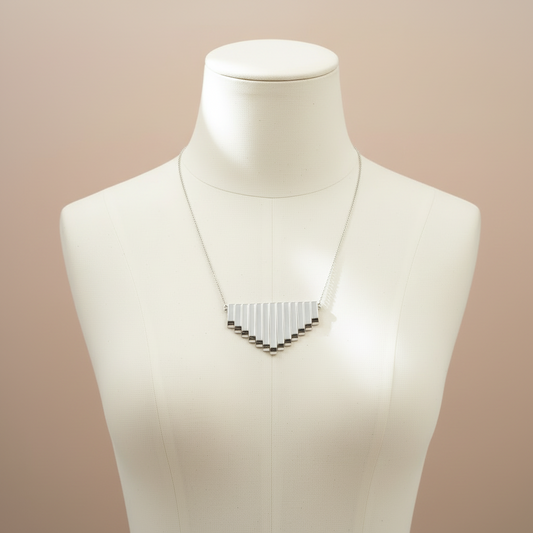"Metallic silver graduated fan beads displayed on jewellery bust as statement necklace"