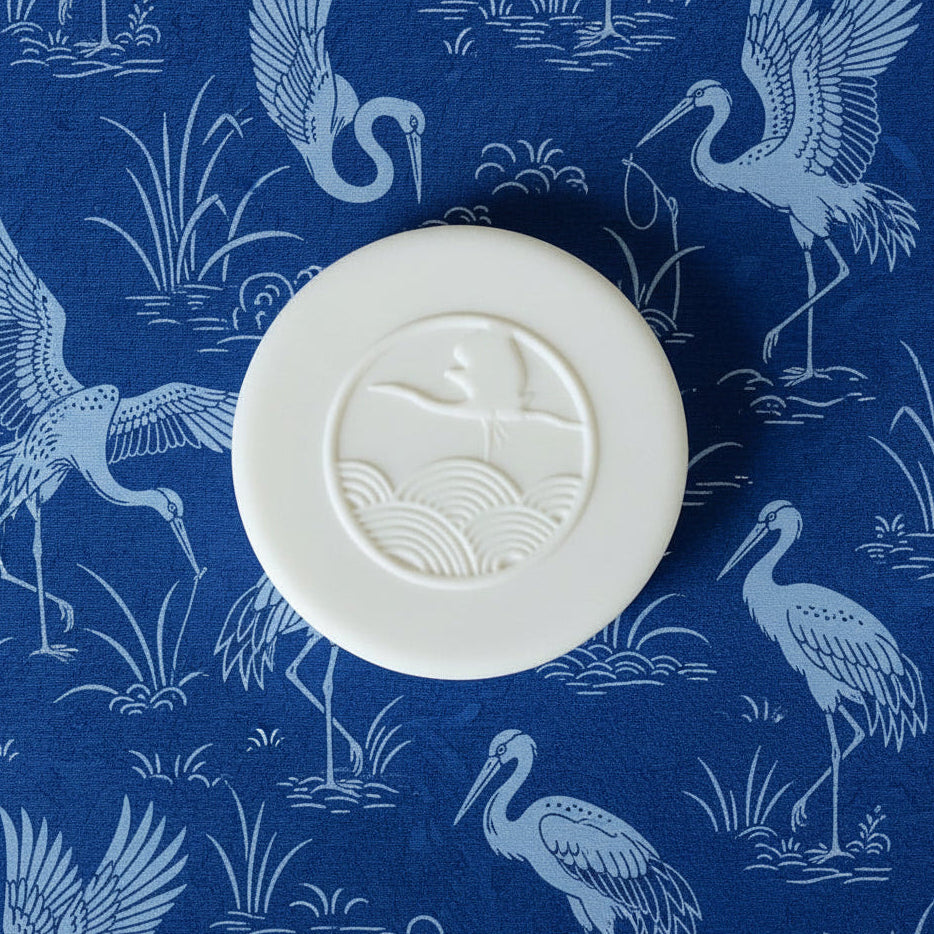 White circular object with a design on a blue background with bird patterns