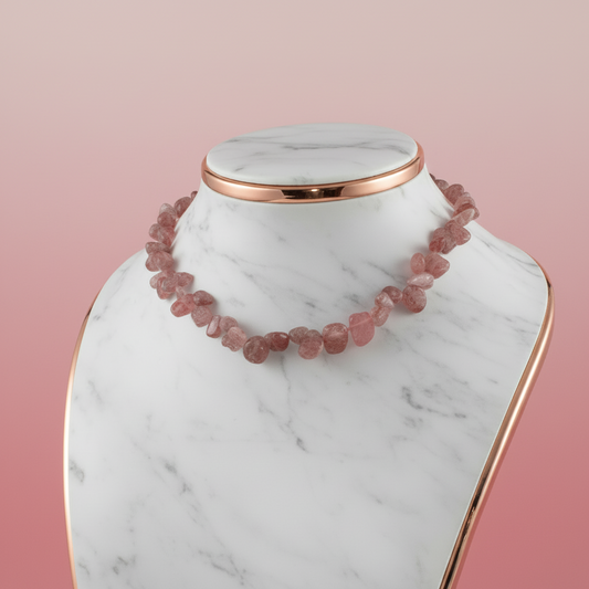 Pink beaded necklace on a marble stand with a pink background