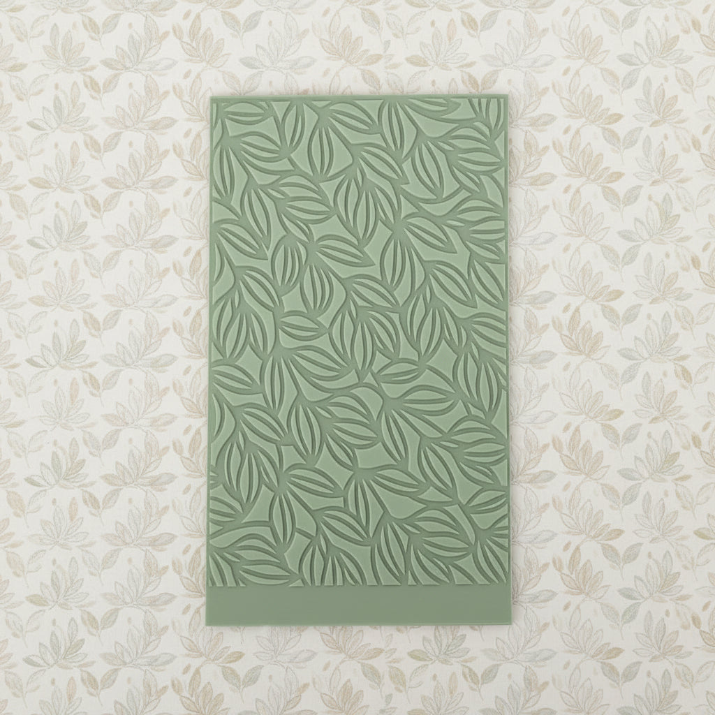 An embossed repeating leaf pattern, photographed against a plain light gray background.
