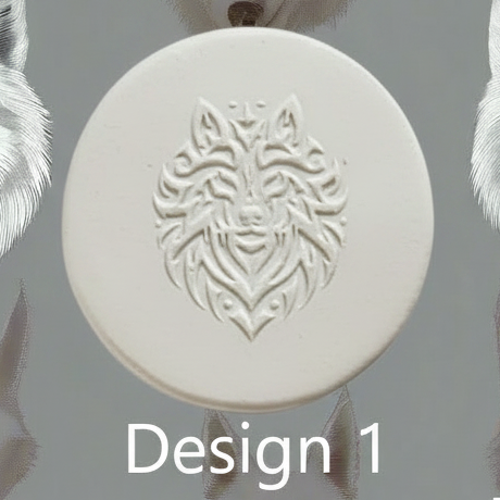 A round white clay with an embossed wolf head design, shown against a grey background with partial white feather-like elements at the sides and the text 'Design 1' at the bottom.