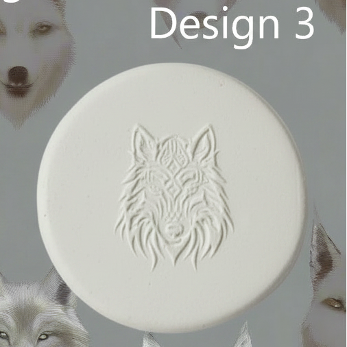 A round white clay with an embossed wolf head design, shown against a grey background with partial white feather-like elements at the sides and the text 'Design 3' at the top.