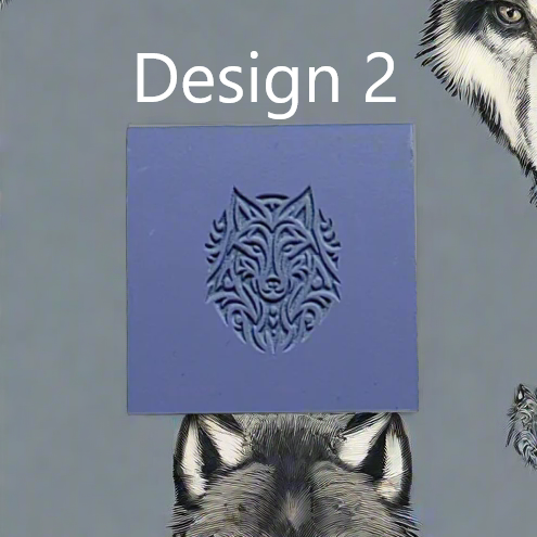 A square blue rubber showing a carved wolf head design, with the text 'Design 2' above it and wolf illustrations partially visible around the edges on a grey background.
