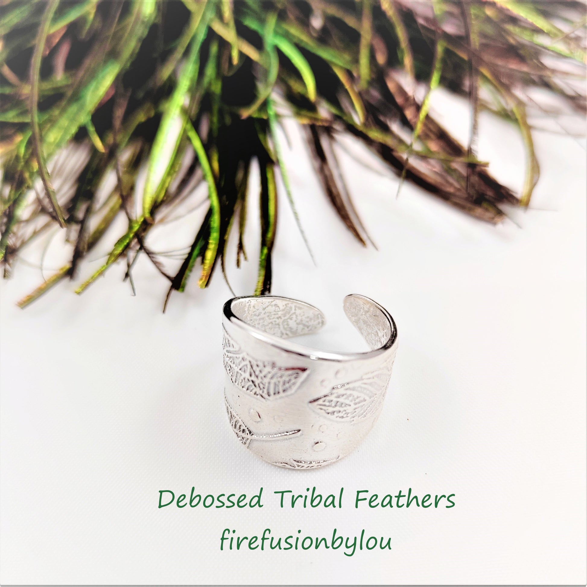A ladies cuff ring made in 999 fine silver with an embossed tribal feathers design wrapped around the ring