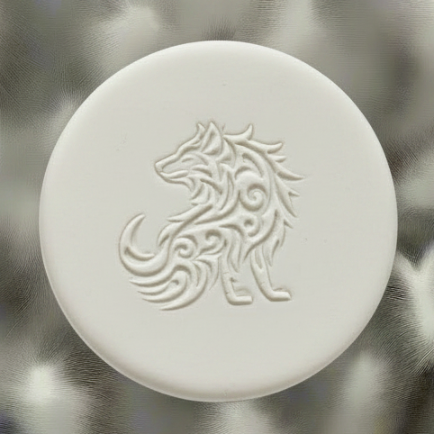 A round clay embossed wolf design embossed in clay, using a rubber texture mat called sitting wolf designs.