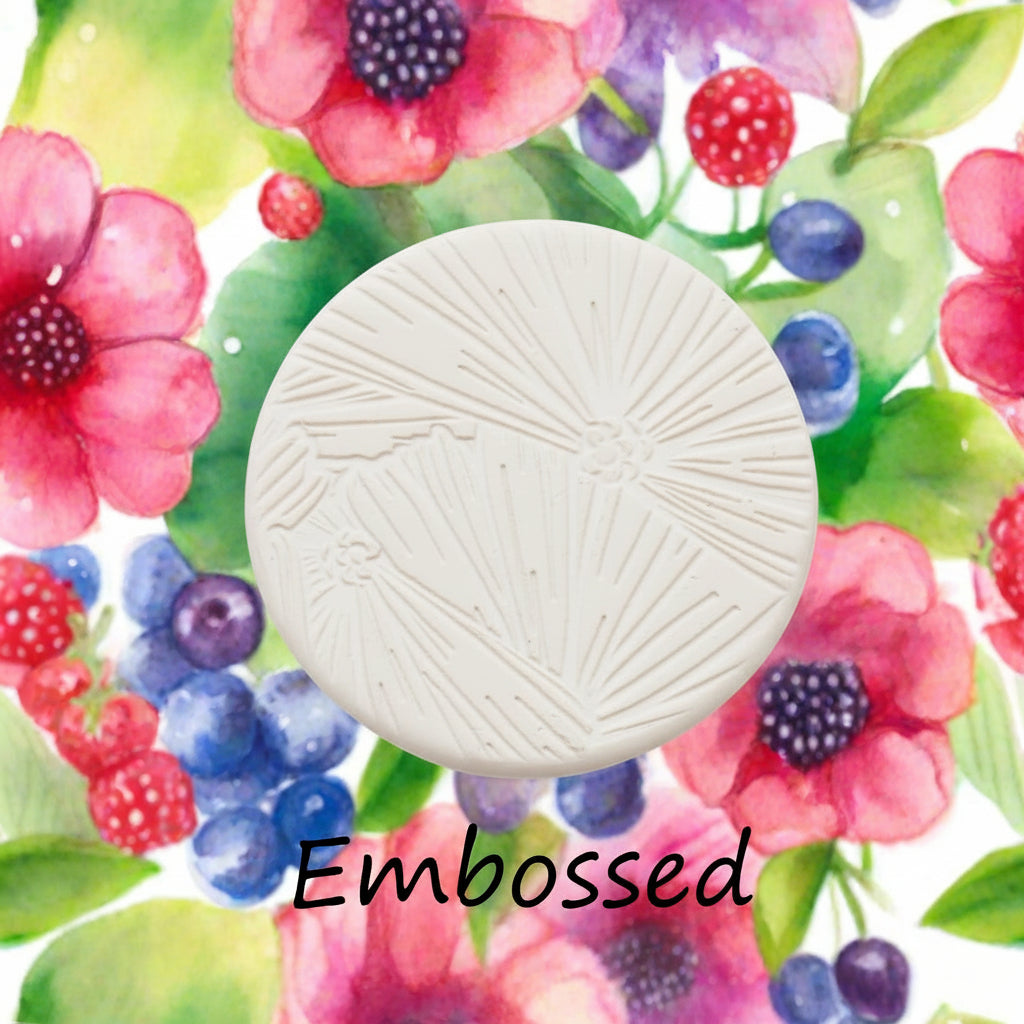 embossed circular object on a colourful floral background with the word 'Debossed'.