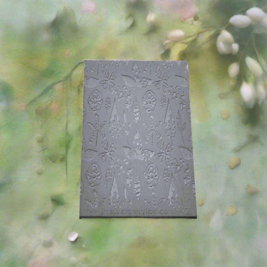 A 95 x 55 mm debossed texture mat with a flower design. Use to make a embossed impression on metal clay and polymer clay.