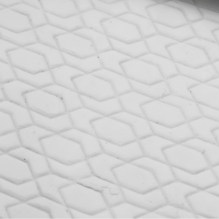 Close-up of textured white clay with a geometric pattern