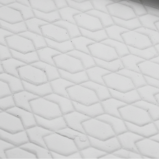 Close-up of textured white clay with a geometric pattern