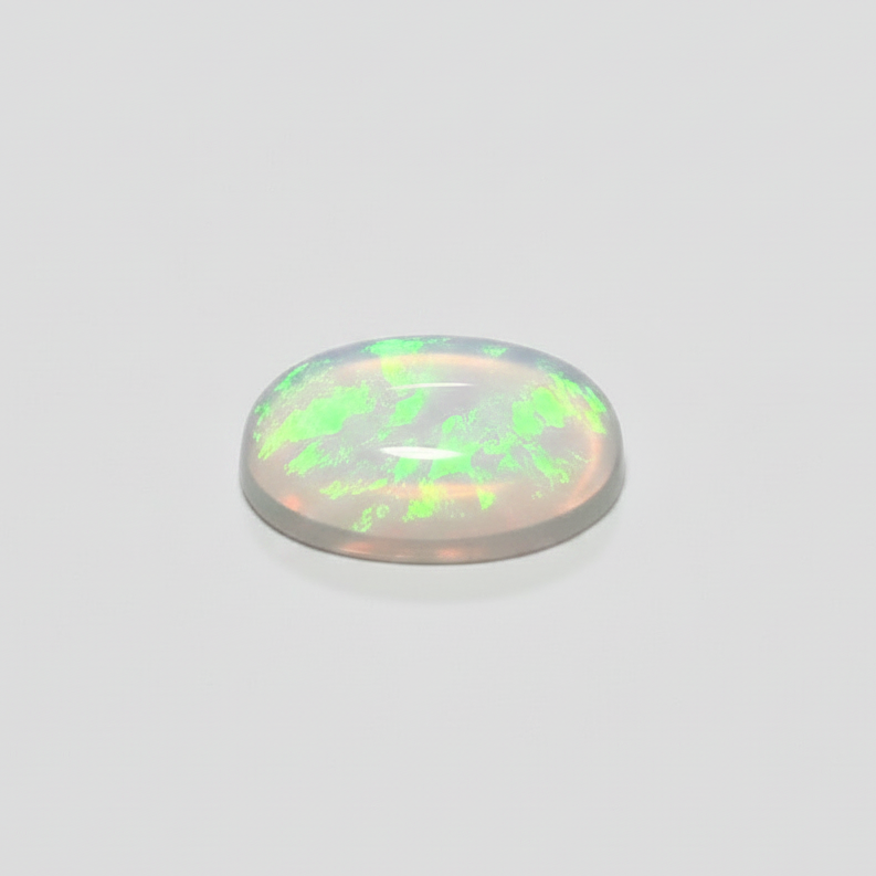 A small, oval-shaped cabochon gemstone with a milky white base and vibrant green iridescent flashes, displayed on a clean, light gray background.