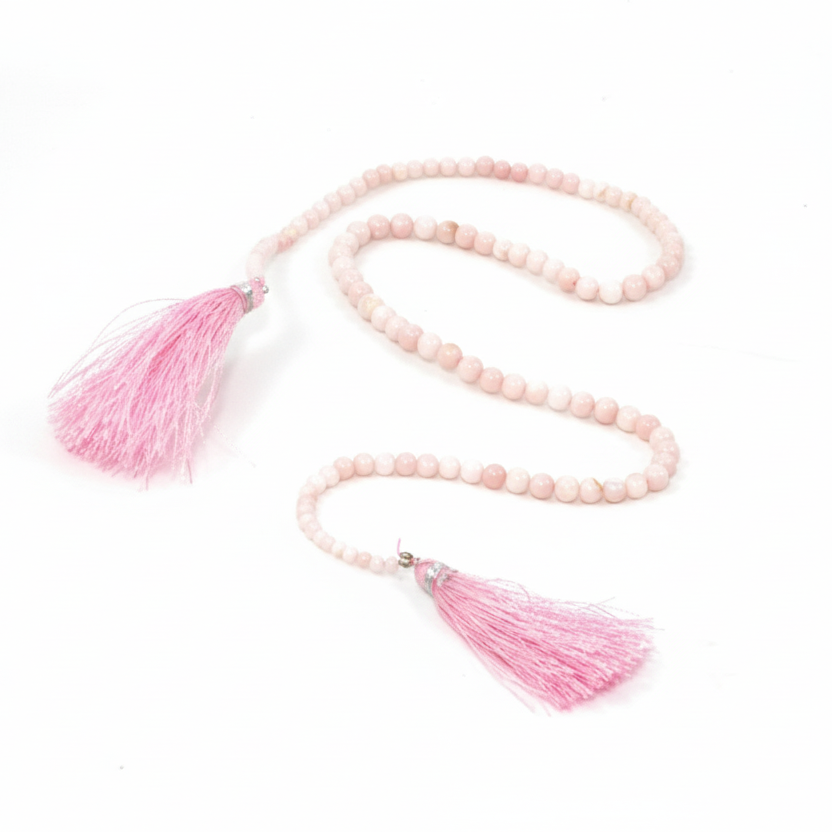 Necklace with pink beads and tassels on a white background