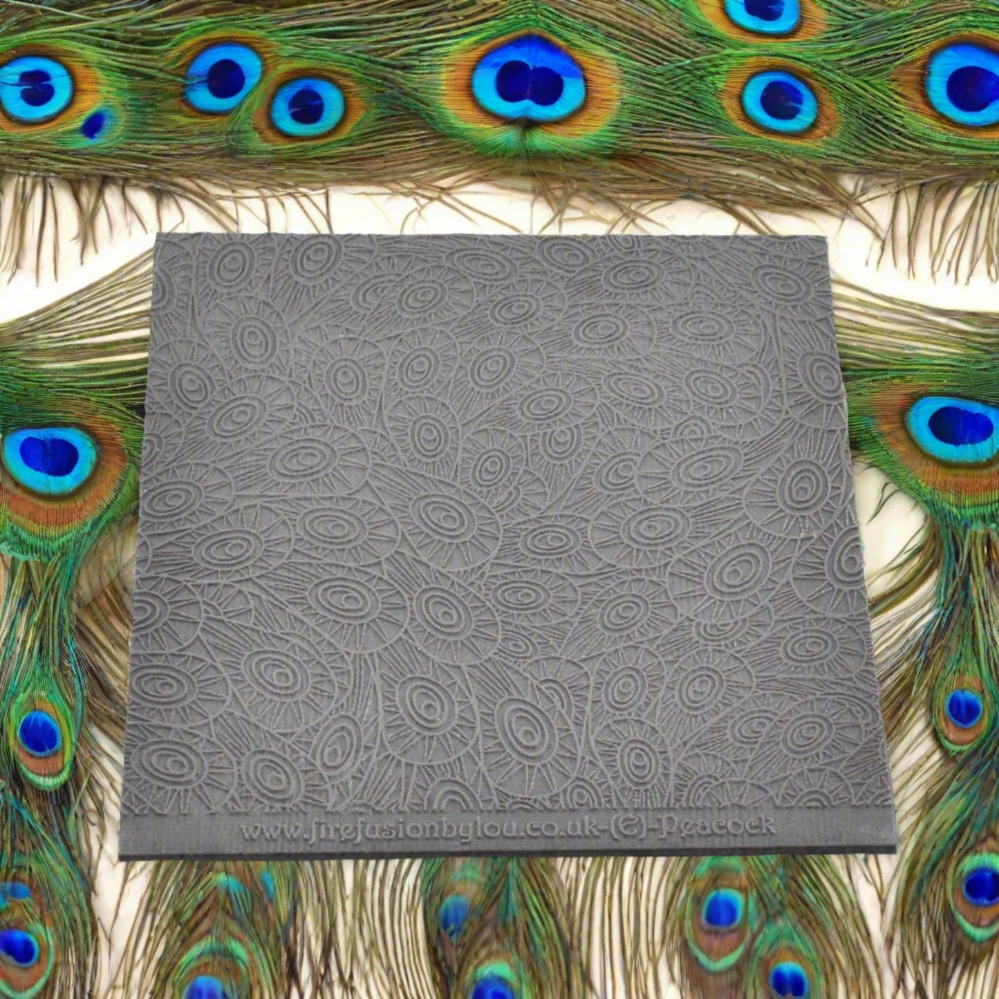 A peacock feather pattern embossed texture mat in grey material. This texture mat will give you an embossed effect on metal clay or polymer clay.