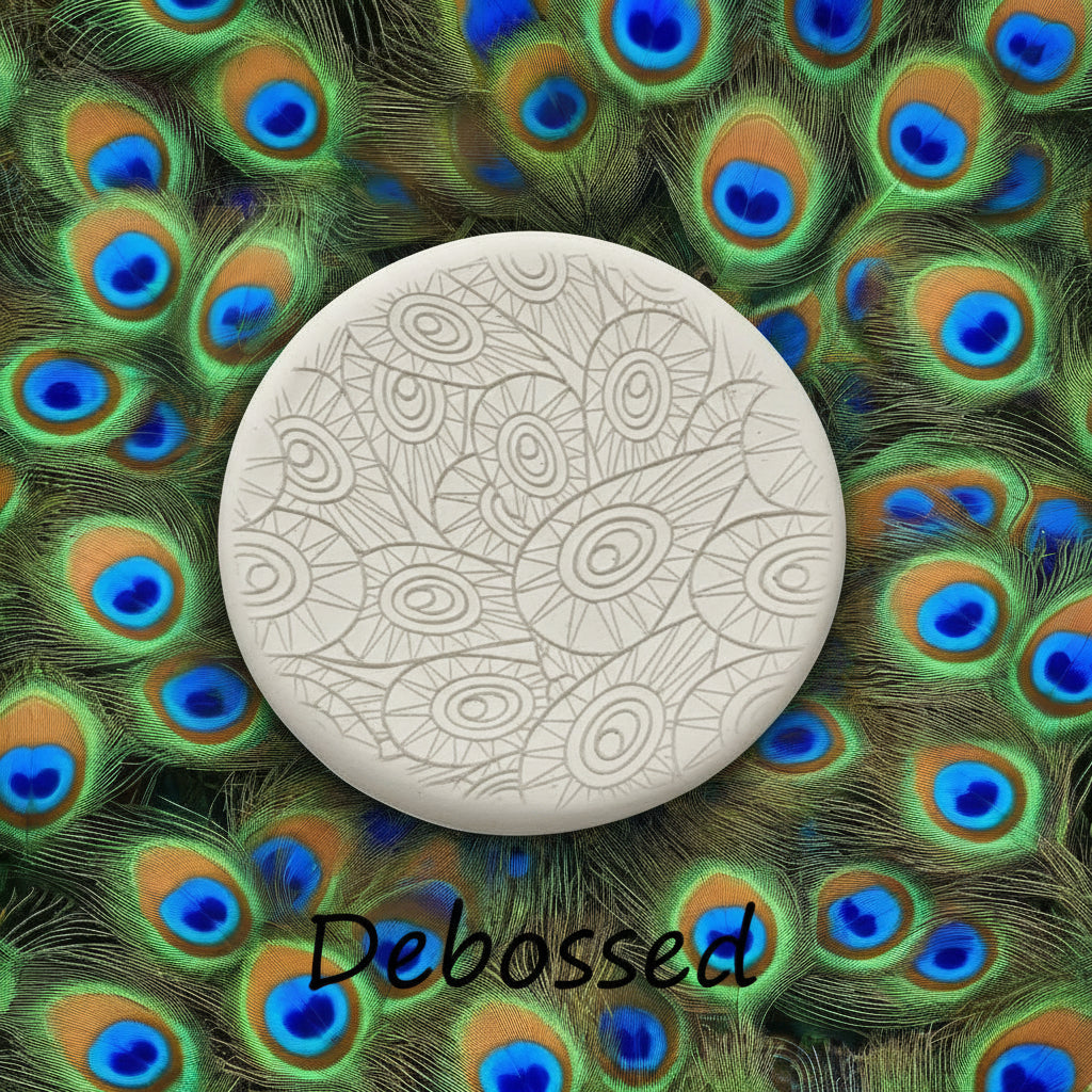 A peacock pattern embossed in clay using a patterned debossed texture mat. 