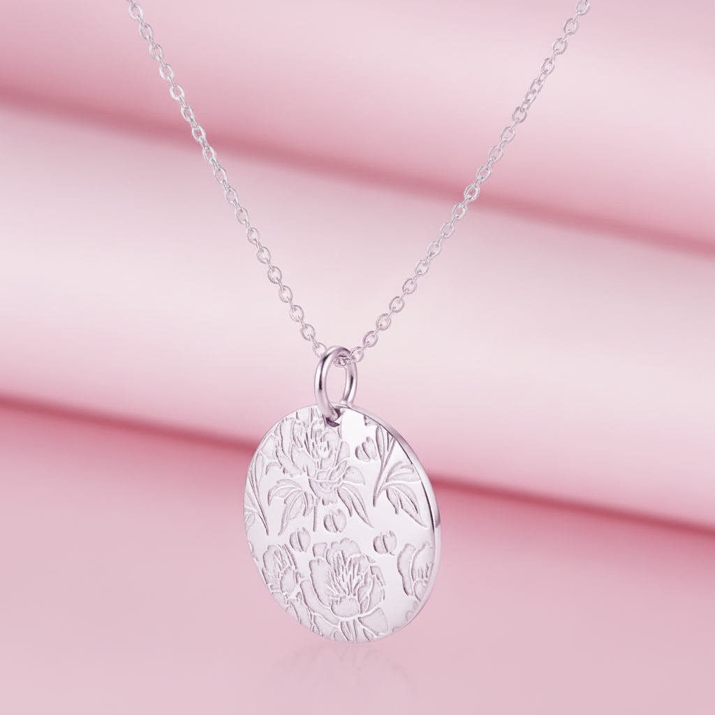 Silver necklace with peonies engraved on a pendant on a beige background