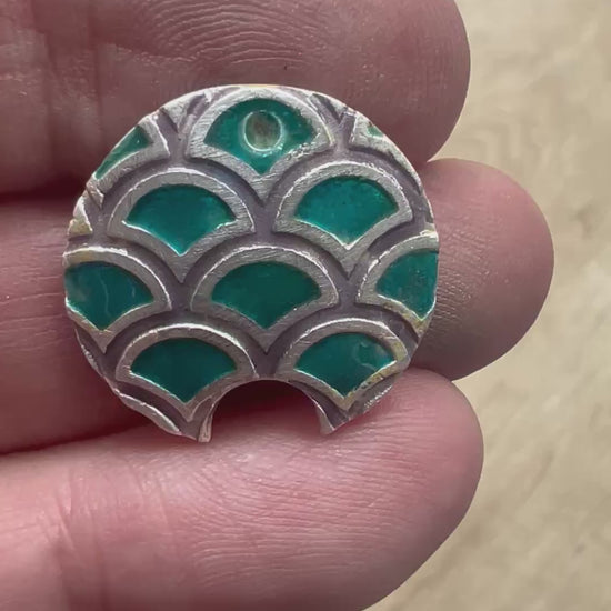 Video of fish scales debossed texture with transparent enamels on it.