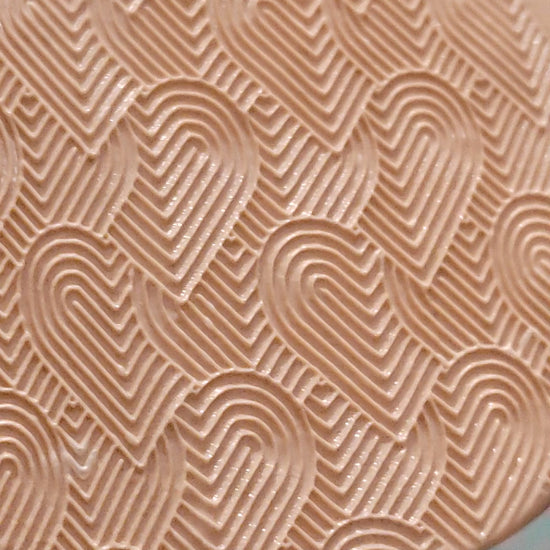 Entwined hearts texture roller, rolled in silly putty.