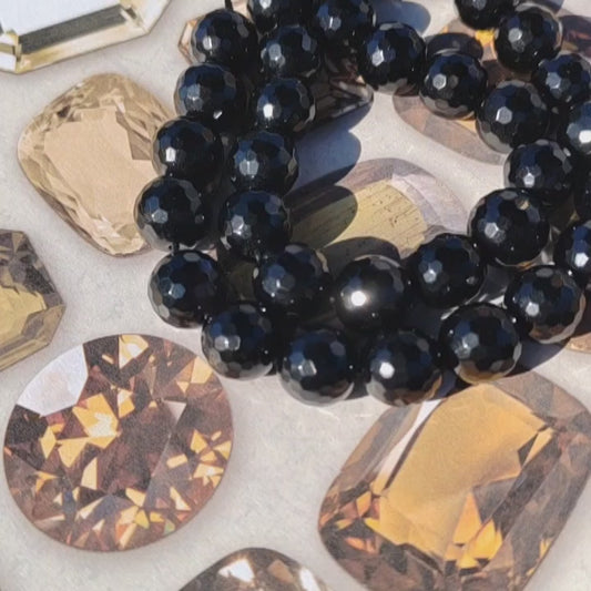 Faceted Black agate beads with a crystal background.