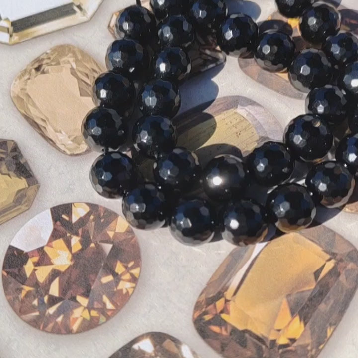 Faceted Black agate beads with a crystal background.