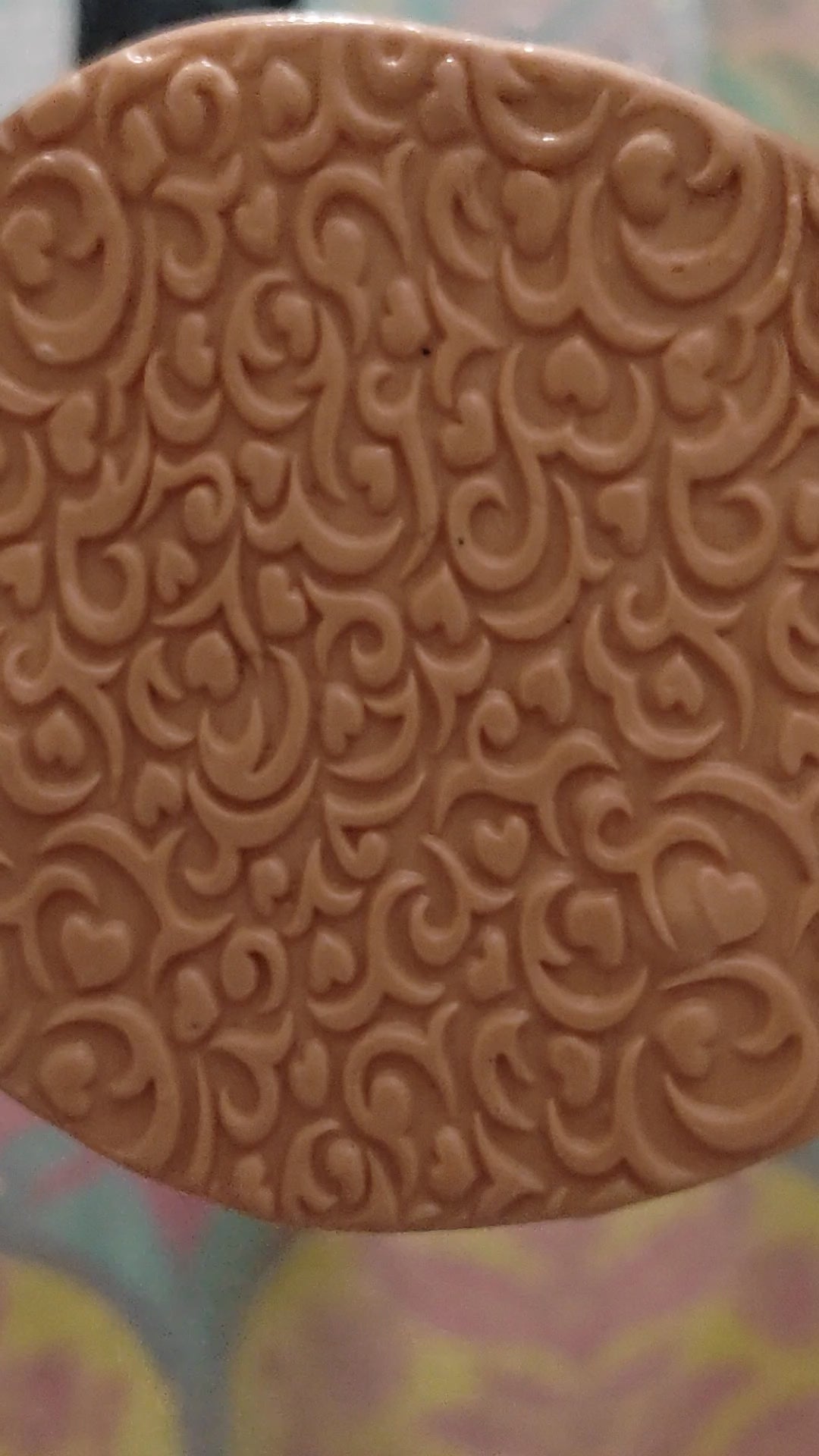 A swirly embossed pattern of hearts and lines In silly putty.