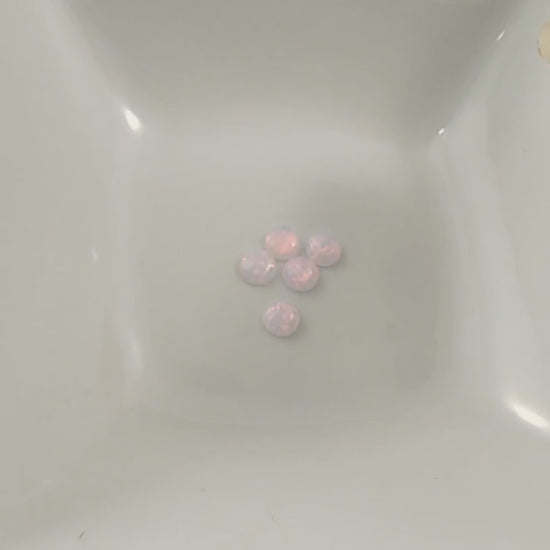 Pink opals with red flashes In a white dish