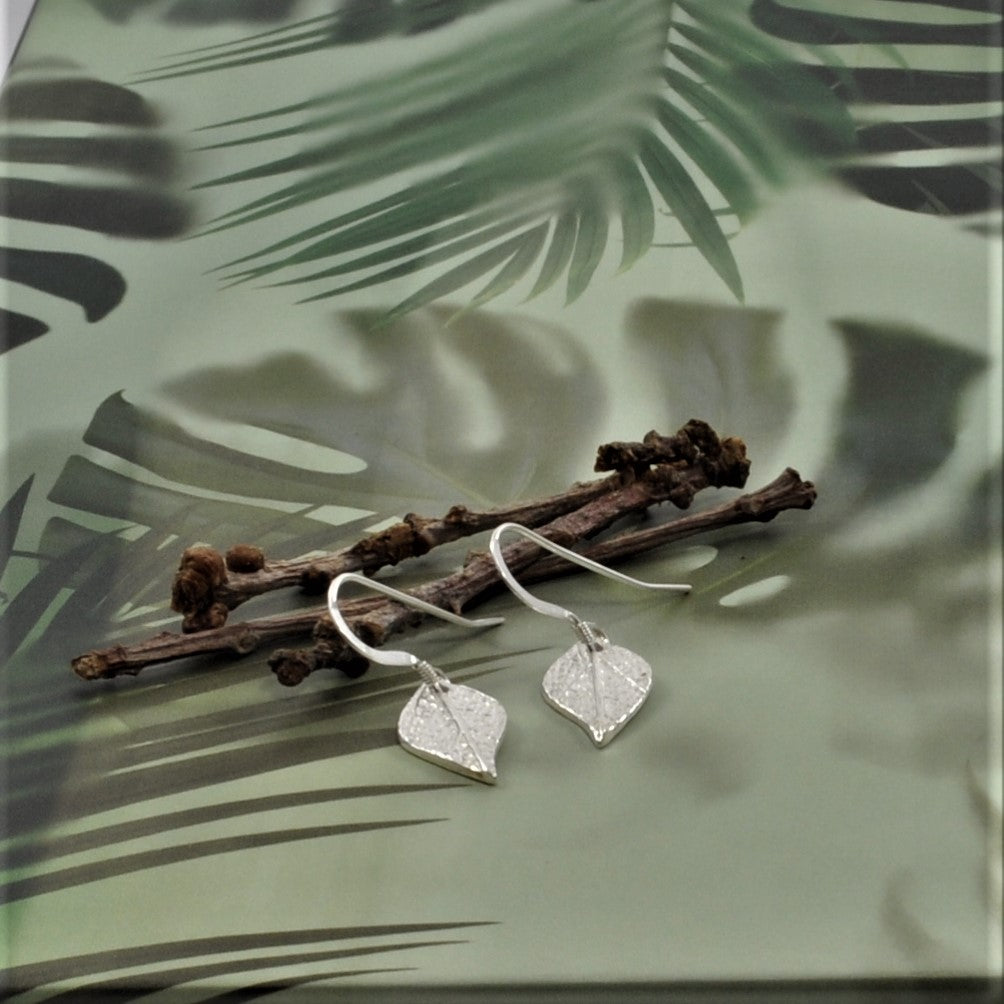 Crafted from 999 fine silver, these earrings each feature a small sage leaf-shaped charm, intricately designed in various patterns and attached to 925 silver French hooks or hoops.