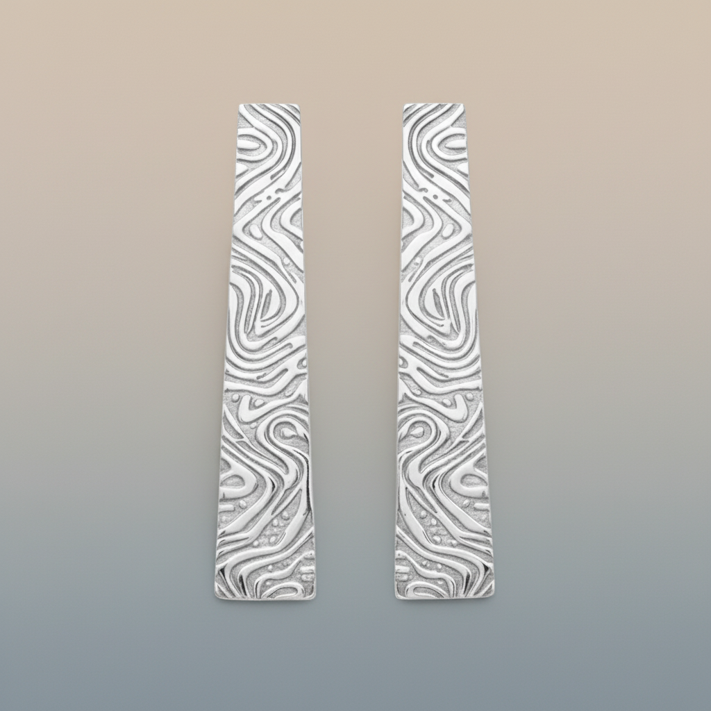 Pair of silver earrings with wavy pattern on a gradient background