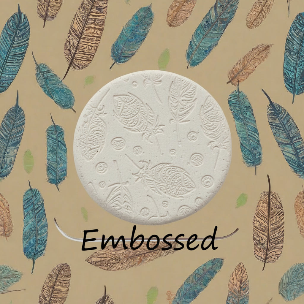 A tribal feather pattern debossed in clay using a patterned embossed texture mat in grey material. This will give you an idea of what it will look like on metal clay or polymer clay.