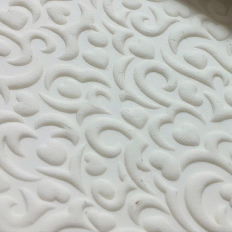 Close-up of a white textured clay with intricate patterns