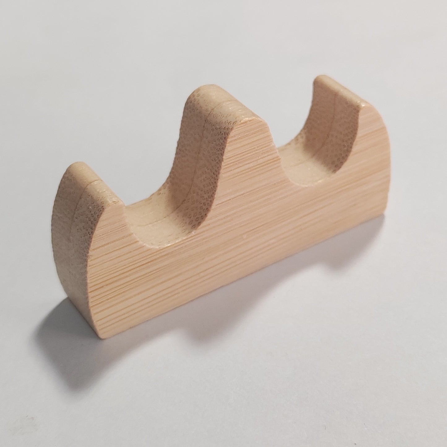 A light natural wood two-tier tool display stand with a visible wood grain texture, photographed on a neutral light grey background.