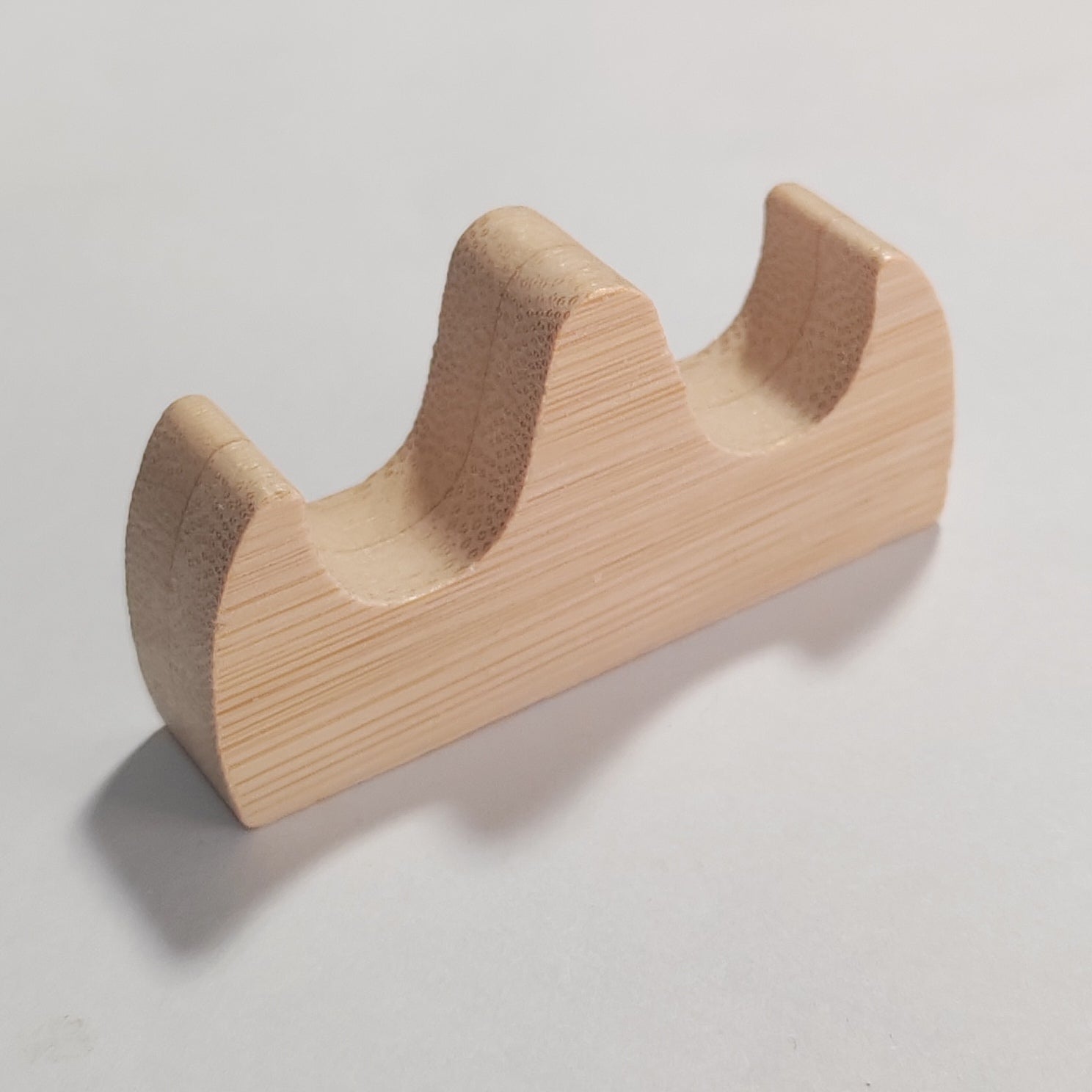 A light natural wood two-tier tool display stand with a visible wood grain texture, photographed on a neutral light grey background.